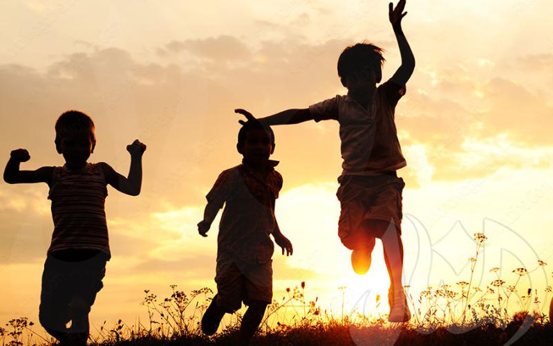 Children playing against sunset backdrop.
